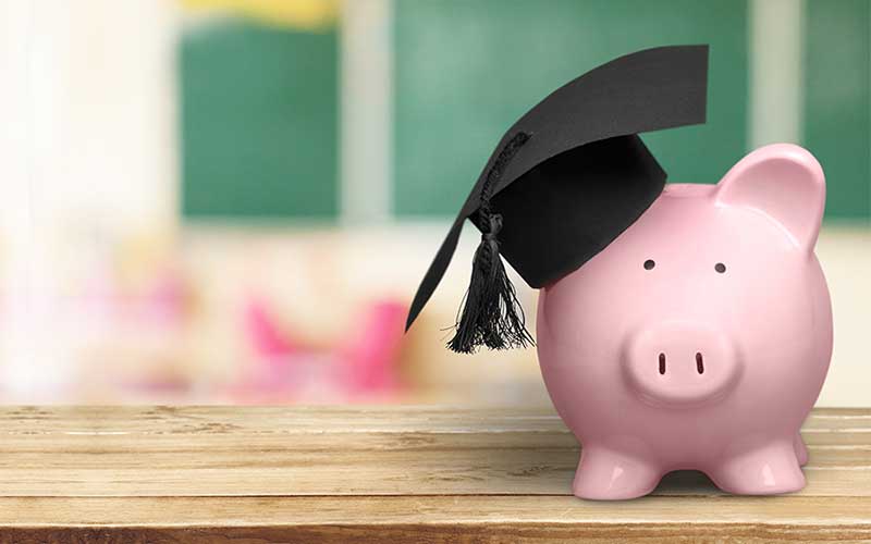 A piggy bank with a graduation cap on it representing student loan debt.