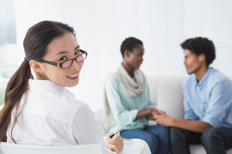A clinical psychologist works in therapy with a couple.