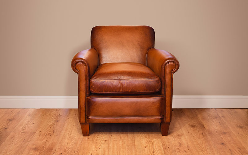An empty leather armchair in an empty room.