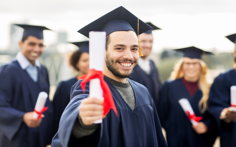 Male graduate smiling holding his diploma